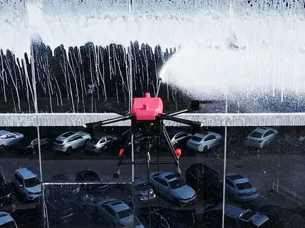 Dron de Dronex enjuagando la espuma de detergente de una fachada vidriada en altura