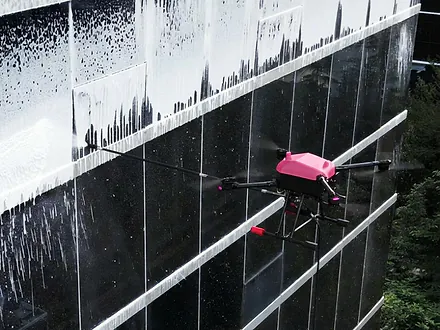 Dron de Dronex aplicando espuma de detergente sobre una fachada de muro cortina vidriado