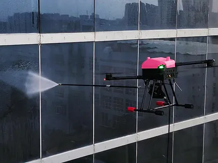 Dron de Dronex aplicando agua a presión con lanza de aspersión sobre una fachada vidriada