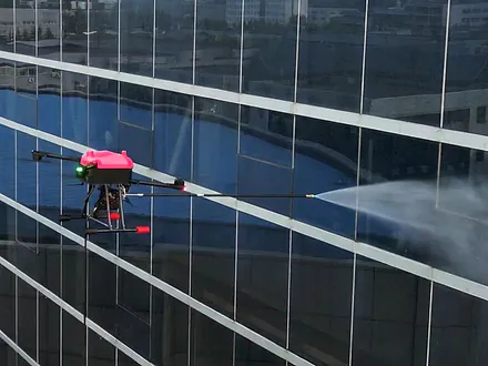 Dron de Dronex proyectando un chorro de agua a presión sobre un muro cortina vidriado