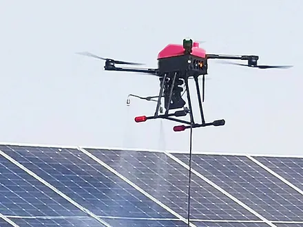 Dron de Dronex asperjando agua sobre el borde de un arreglo de paneles solares