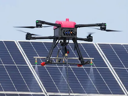 Dron de Dronex en vuelo asperjando agua sobre paneles solares con barra de tres boquillas