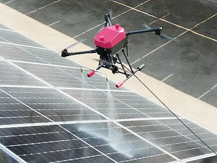 Dron de Dronex lavando una hilera de paneles solares con dos boquillas de aspersión