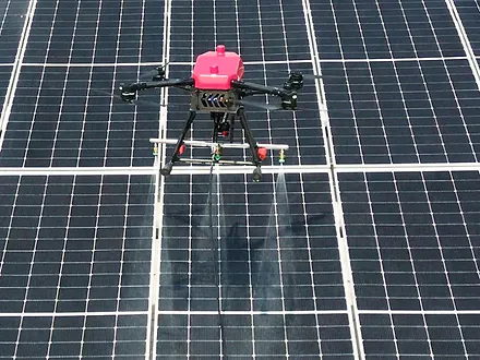Dron de Dronex asperjando agua sobre las hileras de paneles de una instalación fotovoltaica